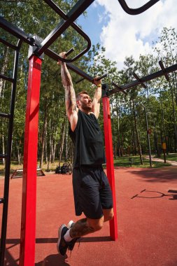 Yatay barda yakışıklı genç erkek eğitimi.