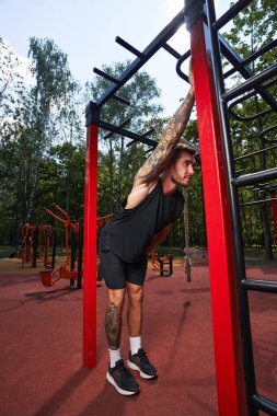 Sporcu erkek dışarıda idmandan sonra esneme hareketleri yapıyor.