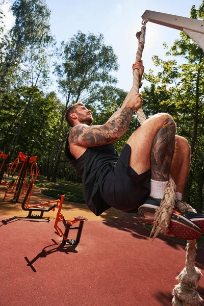 Genç erkek spor sahasında güç egzersizi yapıyor.