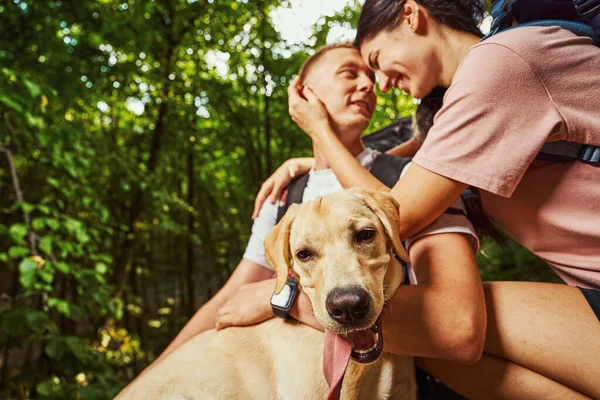 Heureux jeune couple avec chien randonnée en bois — Photo