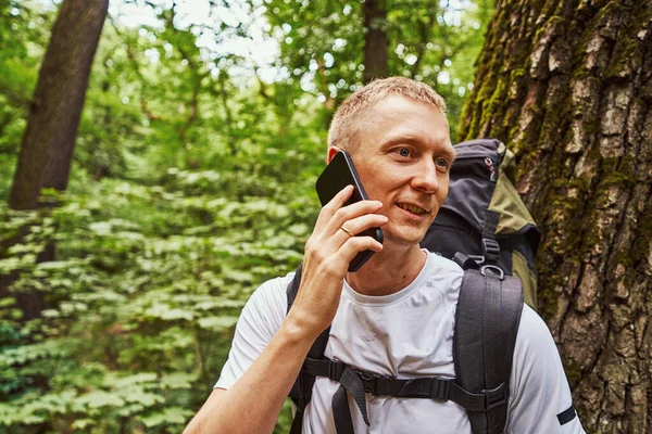 Neşeli genç adam ormanda çağrı yapıyor.