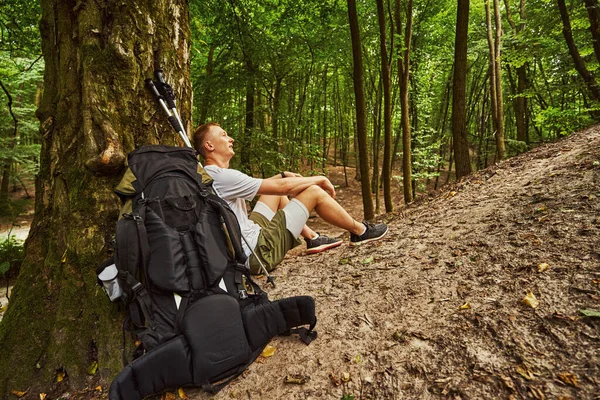 Jongeman moe tijdens nordic walking in het bos — Stockfoto