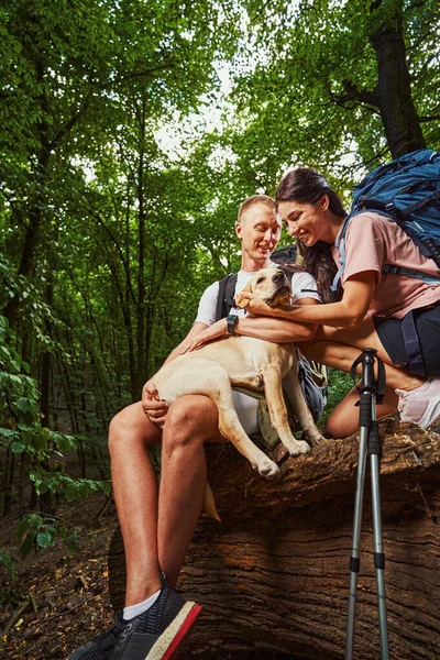 Vrolijk paar genieten van tijd met huisdier in de natuur — Stockfoto