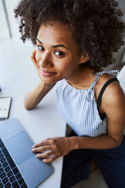 İş yerinde kameraya poz veren çekici bir kadın.