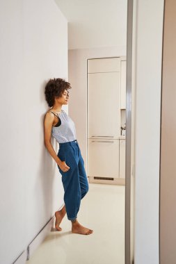 Güzel kıvırcık saçlı kadın duvarda hayal kuruyor