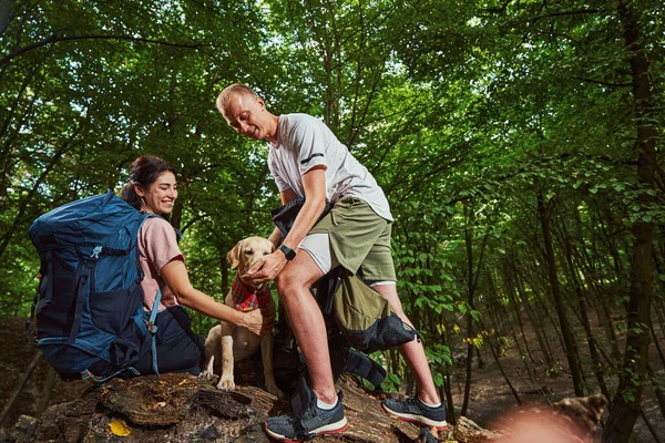 Vrolijk jong paar genieten van actieve tijd met huisdier buiten — Stockfoto