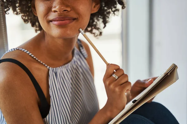 Nöjd dam klädd i trendiga casual kläder sitter vid fönstret — Stockfoto