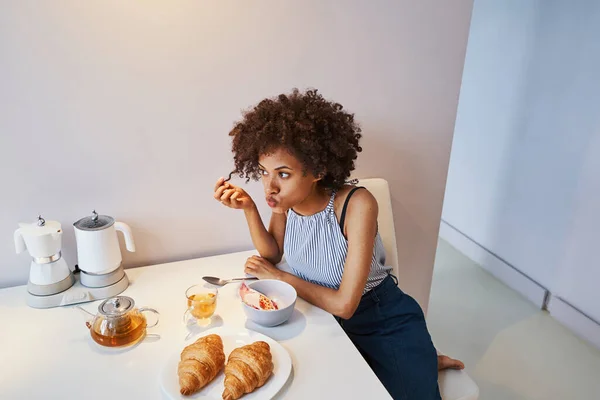 Симпатична кучерява леді відчуває нудьгуючий сніданок — стокове фото