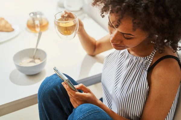 Mulher focada em ler uma mensagem de texto no café da manhã — Fotografia de Stock