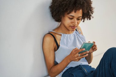 Odaklanmış güzel bayan akıllı telefonuna bakıyor.