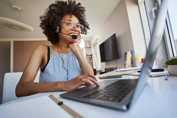 Frilansare i hörlurar med mikrofon sittande vid laptopen — Stockfoto