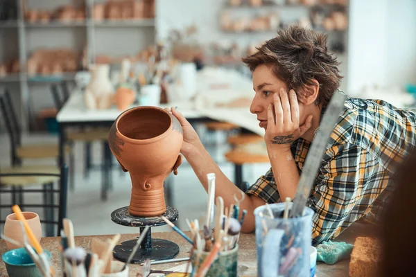 Charming female potter painting pottery in workshop — Stock Photo, Image