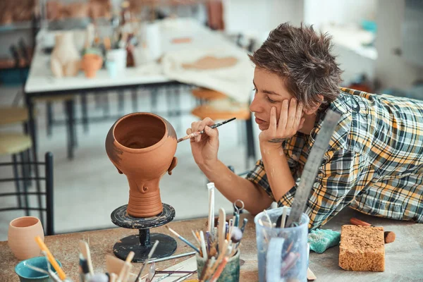 Nice female potter painting pottery in workshop — Stock Photo, Image