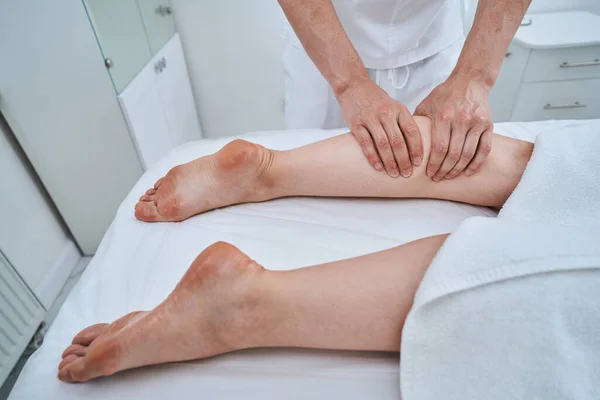 Массотерапевт делает глубокий массаж ног — стоковое фото