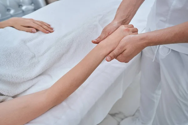 Terapeuta experiente dando uma massagem de mão para um paciente — Fotografia de Stock