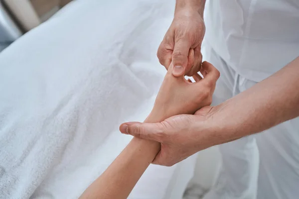 Massoterapista che fa un massaggio alle mani a una cliente donna — Foto Stock