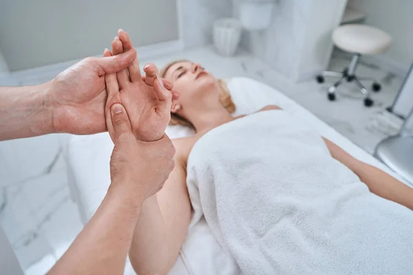 Reflexologista dando uma massagem de mão para seu cliente — Fotografia de Stock