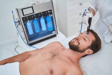 Siyah başlık tedavisi gören genç bir adam.