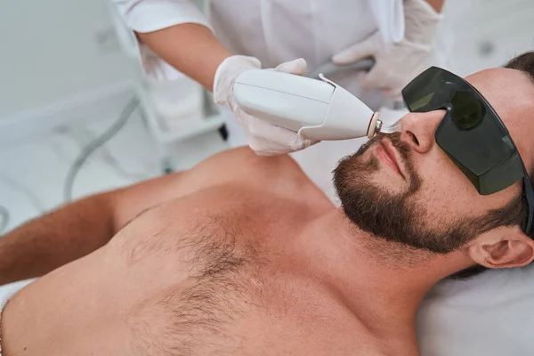 Giovane ragazzo in occhiali protettivi durante una procedura cosmetica — Foto Stock