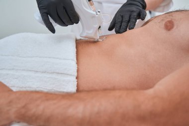 Dermatolog, mezoterapi sırasında bir enjeksiyon cihazı kullanıyor.