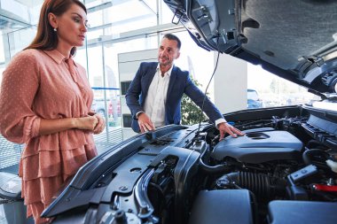 Kadın sürücü motora bakarken konsantre oluyor.