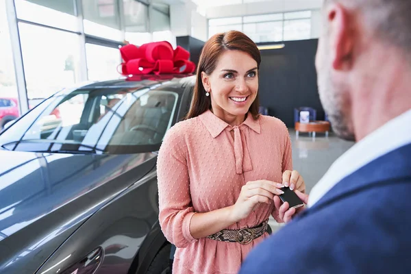 Contented owner of the new car getting her keys — Stock Photo, Image