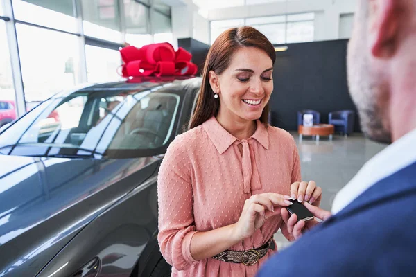 Contented female driver getting the new car in dealership — Stock Photo, Image