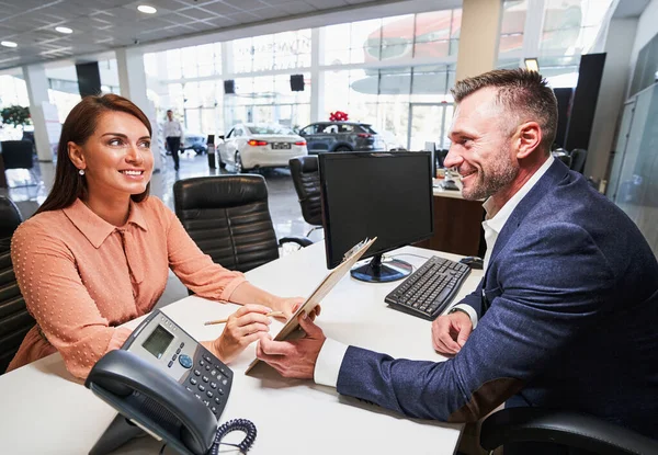 Joyful talk of the woman and car showroom manager — Stock Photo, Image