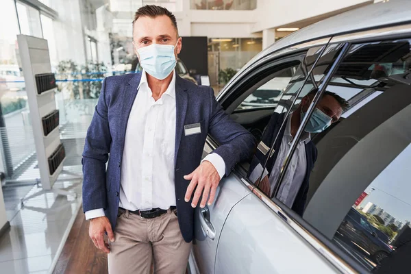 Autoshowroom medewerker draagt medisch masker op het werk — Stockfoto