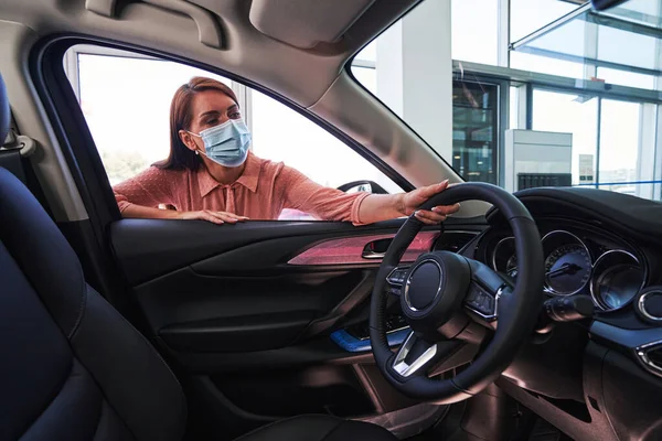 Curious female customer looking at the car salon — Stock Photo, Image