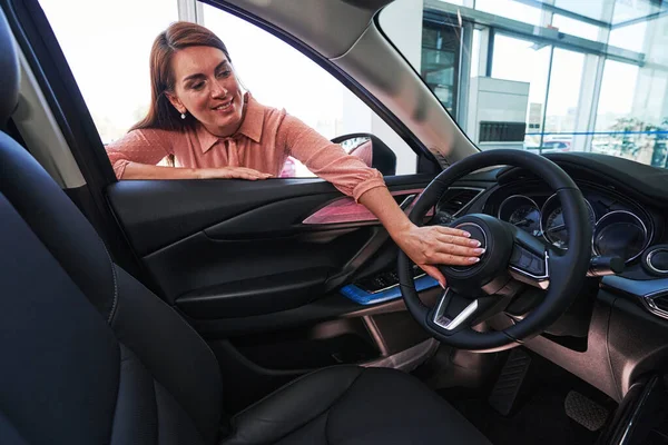 Happy woman getting acquainted with her new vehicle — Stock Photo, Image