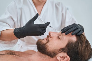 Glabellar çizgisine deri doldurucu enjekte ediliyor.