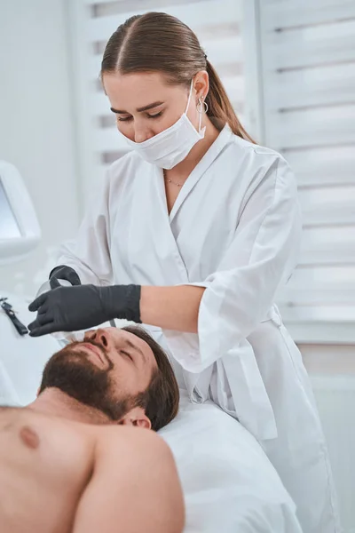 Professional cosmetologist performing a non-invasive skin tightening — Stock Photo, Image