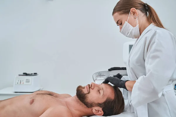 Female dermatologist carrying out the non-surgical ultrasonic skin tightening — Stock Photo, Image