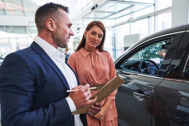 Galerideki sözleşme hakkında soru soran meraklı bir müşteri.