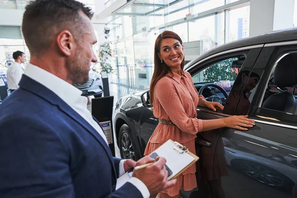 Lächelnde Frau drückt Freude beim Autokauf aus — Stockfoto