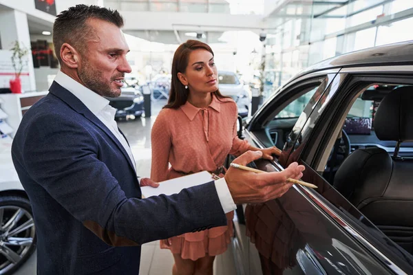 Operatore di concessionaria auto professionale aiutare il cliente — Foto Stock