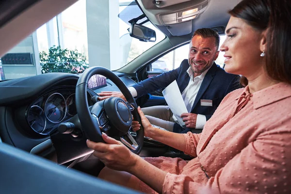 Happy manager demonstrating the navigation system in the car — Stock Photo, Image