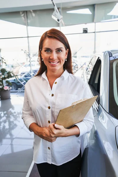 Friendly representative of car dealership at her workplace — Stock Photo, Image