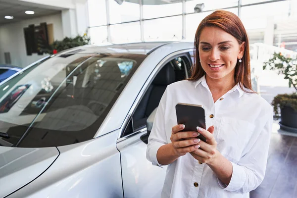 Glückliche Frau mit guter Zeit im Autohaus — Stockfoto