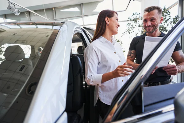 Conversazione amichevole in concessionaria di auto prima dell'acquisto — Foto Stock