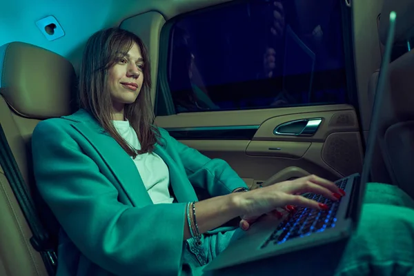 여성 사업가가 자동차에 현대 노트북을 사용하고 있다 — 스톡 사진