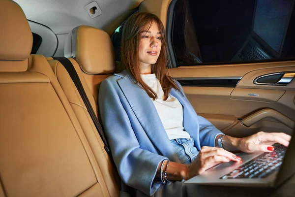 Bizneswoman pracuje nad nowoczesnym notebookiem w samochodzie — Zdjęcie stockowe