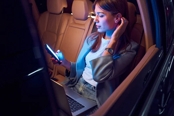 차에서 스마트폰 과 노트북을 사용하는 여성 — 스톡 사진
