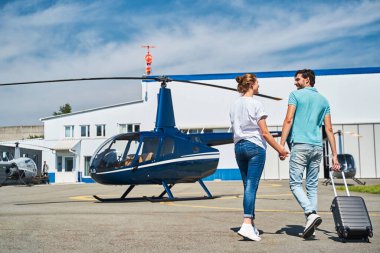 Bagajlı romantik beyaz çift helikoptere yaklaşıyor.