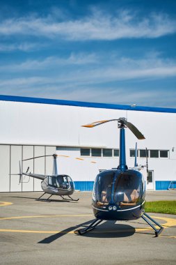 Boş helikopterler açık havada iniş pistinde duruyor.