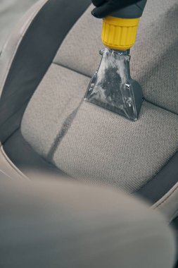 Uzman süpürgeler araba servisinin ön koltuğunu kaldırdı.