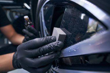 Eldivenli işçi arabanın tekerlek lastiğini parçalıyor. Otomobil bakımı