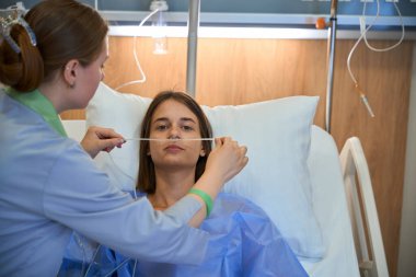 Hastanedeki hastaya oksijen tüpleri takan bir hemşire. Tıbbi konsept. Kan ozonu terapisi