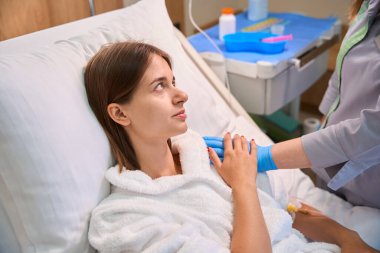 Hastanenin koğuşunda bir kadını teselli eden bir hemşire. Tıbbi konsept